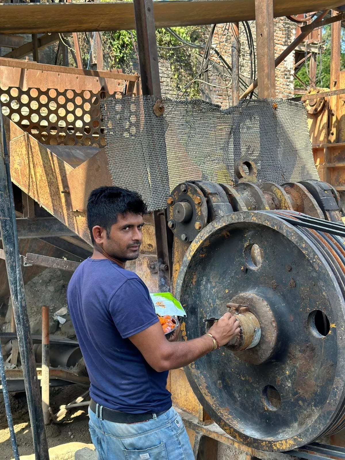 Field worker beside construction plant and heavy equipment