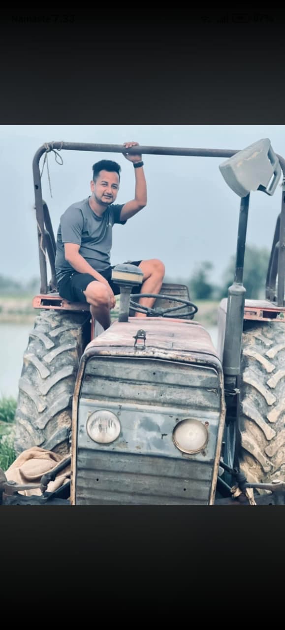 Construction team member operating a tractor in the field